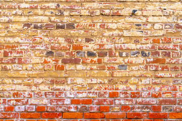 Old red brick wall. Peeling white paint on a red wall.