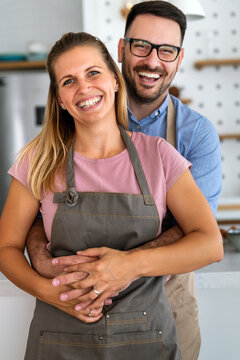 Attractive couple is cooking together organic healthy food in kitchen.