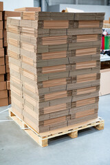 cardboard boxes on a pallet stack of wooden pallets