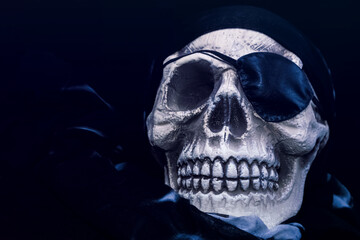 Skull with eye patch and black headscarf. Pirate skull on dark background.