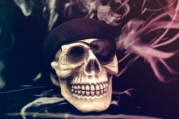 Skull with eye patch and black headscarf. Pirate skull on dark background.