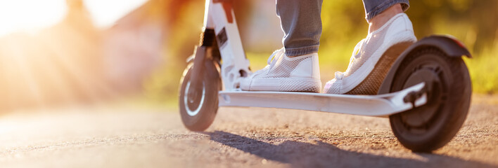Woman riding on scooter on asphalt road in summer © candy1812