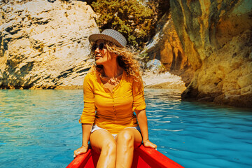 Cheerful attractive adult woman smile and enjoy canoe jayaj trip journey on a blue river in a canyon. Tourist and outdoor new leisure activity. Summer holiday vacation people lifestyle