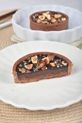 luxury home baked rocher dark rich chocolate tart in 3 layer with hazelnut mixed nuts and gold foil in white background halal dessert menu for hotel cafe