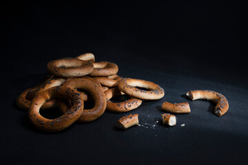Sushki, bagels, taralli, bakery products with poppy seeds on a dark background