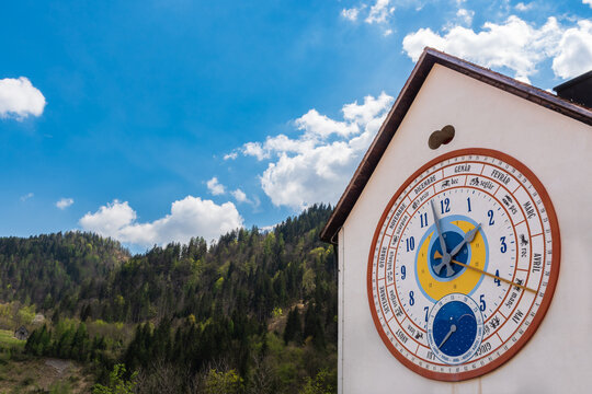 Calendar clock on a house facade. Pesariis village has a clock and watch making history dating back to the early 18th century. Carnia, Udine province, Friuli Venezia Giulia, Italy.