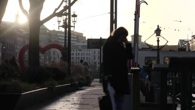 People and Tram Passing by Brunnsparken in Gothenburg City Center at Sunset