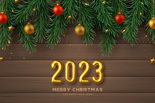 2023 New Year sign. Merry Christmas banner with realistic golden 3d numbers, gold and red balls, pine branches and stars. Wooden background. Vector illustration.