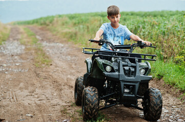 Fototapeta na wymiar Boy drive four-wheller ATV quad bike.