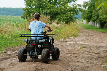Boy drive four-wheller ATV quad bike.