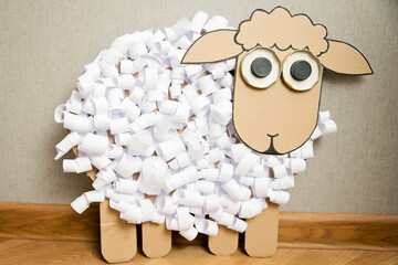 The boy cuts a paper sheep. DIY toy. Activity at home. Early education, fine motor skills....