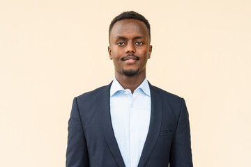 Portrait of young handsome black businessman smiling