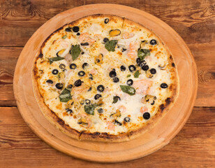 Pizza with seafoods on the round wooden pizza board