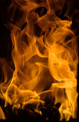 Flame. Orange flames on a dark background. The texture is a raging fire of bright orange color on a...