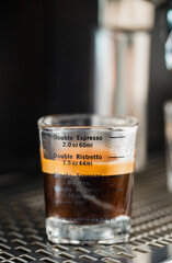 Pouring coffee stream from professional machine in cup. Barista man making espresso shot by bottomless, using filter holder. Flowing fresh ground coffee. Drinking roasted black coffee in the morning.