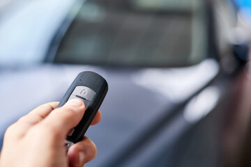 The car owner holds in his hand a remote control device for keyless entry. Close-up, selective focus