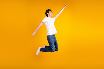 Fototapeta na wymiar Full body profile side photo of young guy good mood jump fly superman power isolated over yellow color background