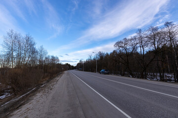 Fototapeta premium Epic spring landscape by the river. The flood of the river in early spring. A colorful sunset is reflected in the water. March evening landscape.