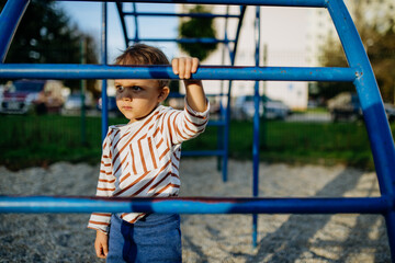 A little boy playing on outdoor playground.