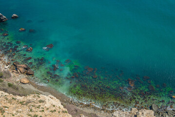 Top view of the rocky coast of the sea with turquoise water.