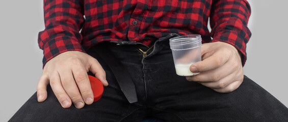 Man takes semen analysis. Spermogram. Concept. Male with his pants unbuttoned symbolizes...