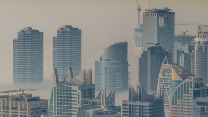 JLT skyscrapers covered by morning fog near Sheikh Zayed Road aerial timelapse. Residential buildings