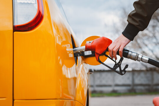Unrecognizable man refueling car from gas station filling benzine gasoline fuel in car at gas station. Petrol high prices concept
