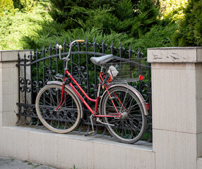 Bicycle tied to a fence on the street