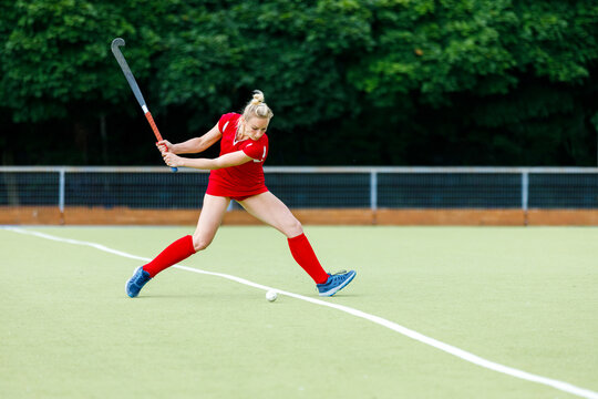 Young Woman Field Hockey Player Hit The Ball In Attack On Game.