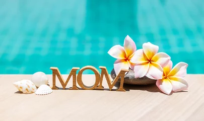 Poster Happy Mother's day in tropical concept, mom wooden text with seashell and plumeria flower over blue water background, summer outdoor day light © sirirak