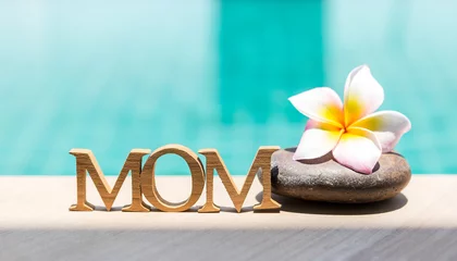 Wandaufkleber Happy Mother's day in tropical concept, mom wooden alphabet with plumeria flower over blue water background, summer outdoor day light © sirirak
