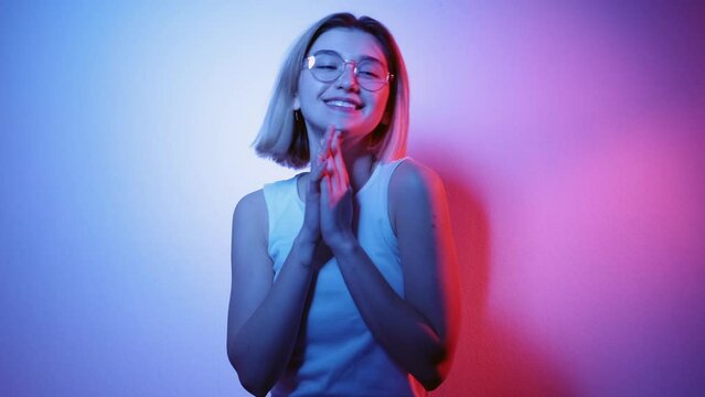 Party joy. Neon light people. Positive lifestyle. Happy inspired smiling girl enjoying dancing in pink blue glow isolated on dark uv color gradient.