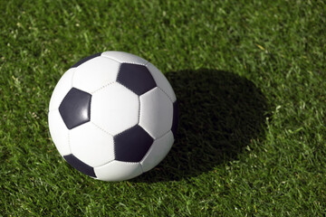Classic soccer ball on grass field. View from above on retroc classic football ball. Sports soccer background