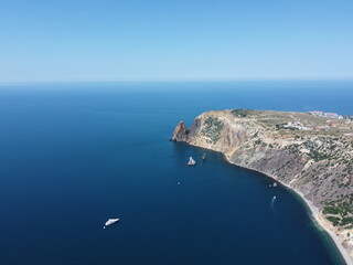 Aerial view from above on calm azure sea and volcanic rocky shores. Small waves on water surface in motion blur. Nature summer ocean sea beach background. Nobody. Holiday, vacation and travel concept