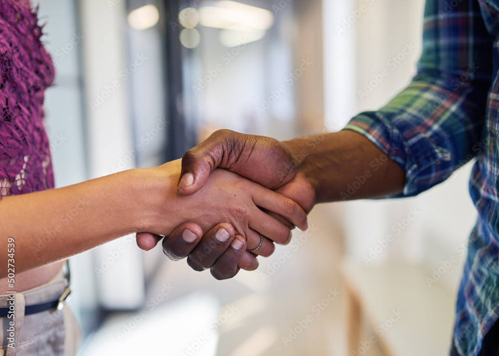 Wall mural an extreme close up of a handshake where a man and woman shake hands