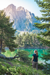 Young Attractive Woman With Backpack hiking in a Beautiful Lake wild Landscape in summer. Discovery Travel Destination Concept