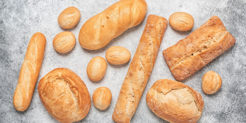 Fresh bread on grunge gray background. Top view, flat lay, banner.