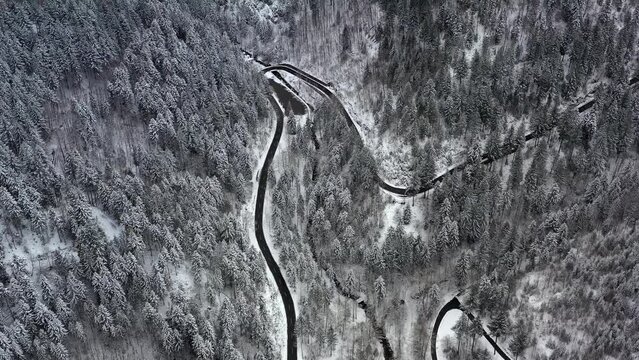 Drohnenaufnahme, Drohnenflug, Video von oben &uuml;ber eine Landstra&szlig;e und den Eingang zum Wasserfall Allerheiligen mit Parkplatz im Winter, Schnee, leichter Schneefall, Serpentine, Oppenau, Schwarzwald, B
