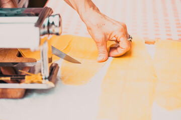 woman's hands cutting home made pasta