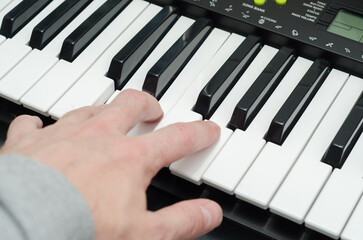man's hand on the keys of a synthesizer