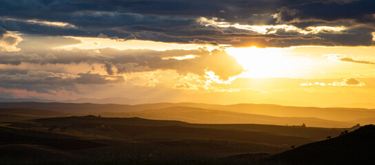 Fototapeta premium amazing sunset sky over green hills in early summer