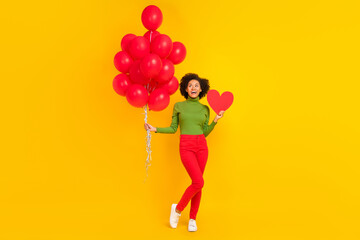 Full body photo of young excited girl dreamy hold many balloons birthday event isolated over yellow color background