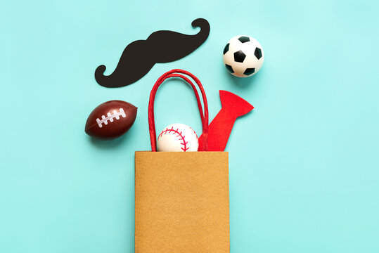 Happy Father's Day. Top view of shopping bag with false mustache,false bow tie and sports balls with space for text. Father's Day celebration concept