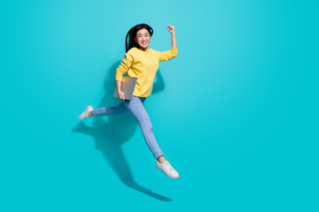 Full length photo of funny lucky lady dressed yellow sweater jumping runnig gadget empty space...