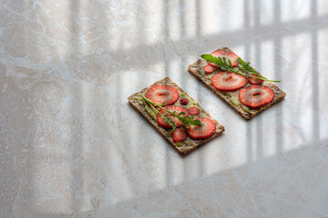Assortment of sweet toasts. Strawberries, cream cheese and blueberries, kiwi and blueberries. Light background, top view.
