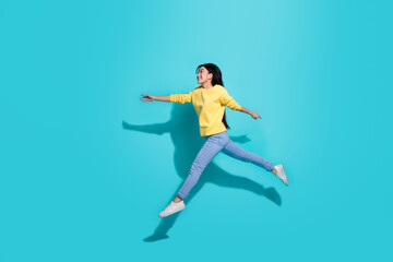 Fototapeta na wymiar Full length photo of sweet cute lady dressed yellow sweater jumping running empty space isolated turquoise color background
