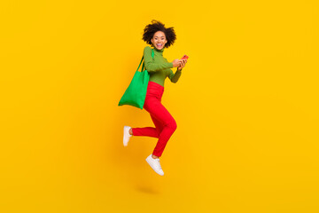 Fototapeta na wymiar Full body profile side photo of young cheerful girl jump active use mobile order purchase store isolated over yellow color background