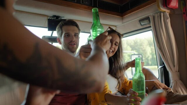Group of young friends spending time inside the camper on drinking beer and relaxing. Shot with RED helium camera in 8K  