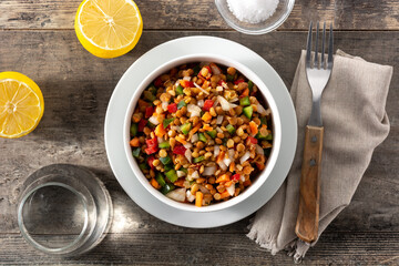 Lentil salad with peppers,onion and carrot in bowl on wooden table	