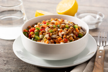 Lentil salad with peppers,onion and carrot in bowl on wooden table	